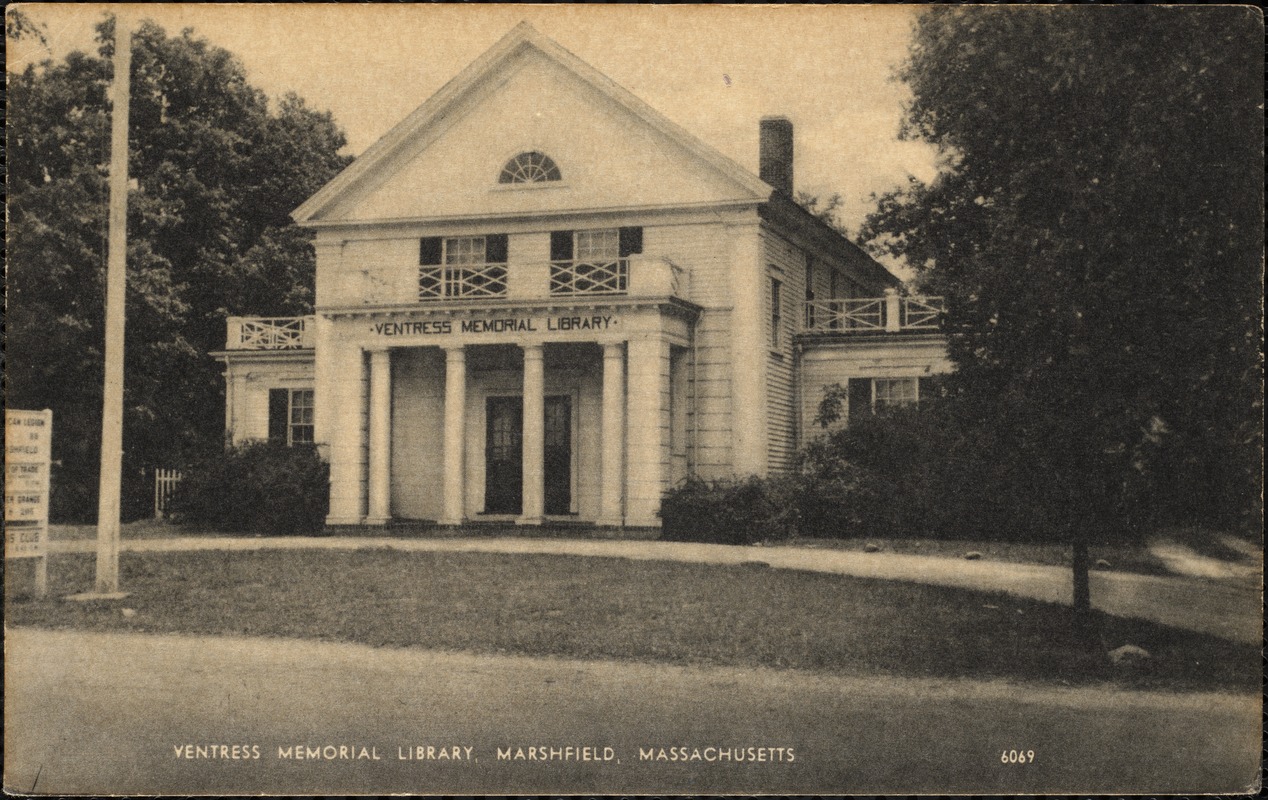 White library building from 1900s on a street.