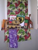 Photograph of red and green cloth, instruments and several books which are part of the Arts and Music of Africa and Asia Kit