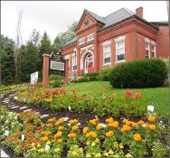Photo of the Meredith Library, NH with flowers in bloom