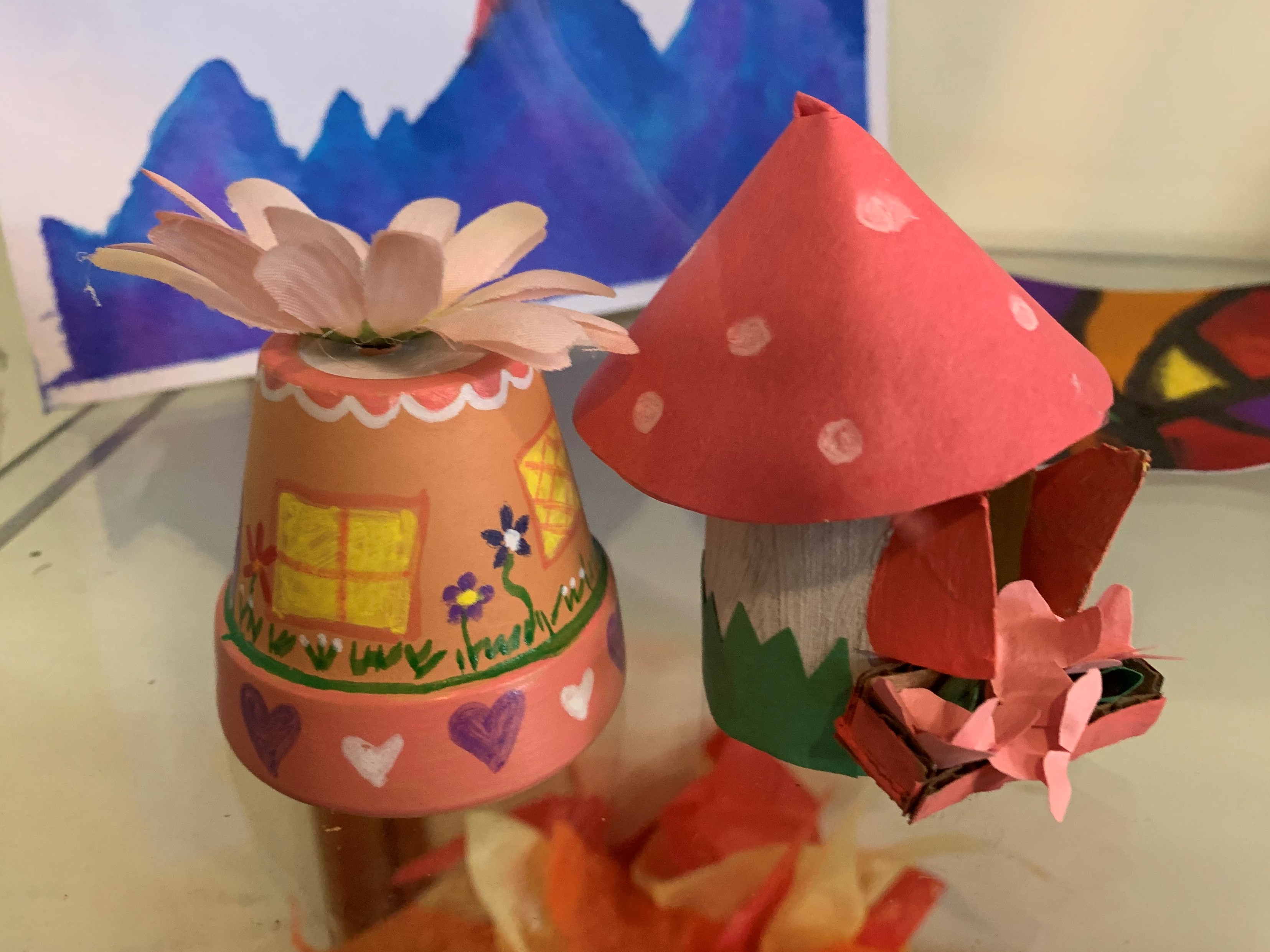 painted flowerpot that looks like house and mushroom house made out of paper